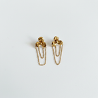 Boucles d'oreilles dorées sur fond blanc