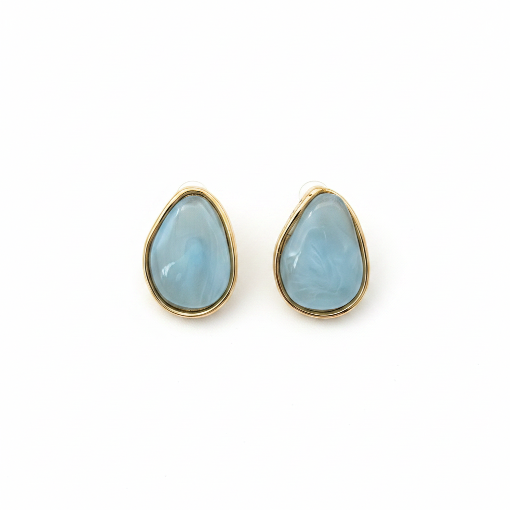 Boucles d'oreilles goutte pierre bleue dorée fond blanc